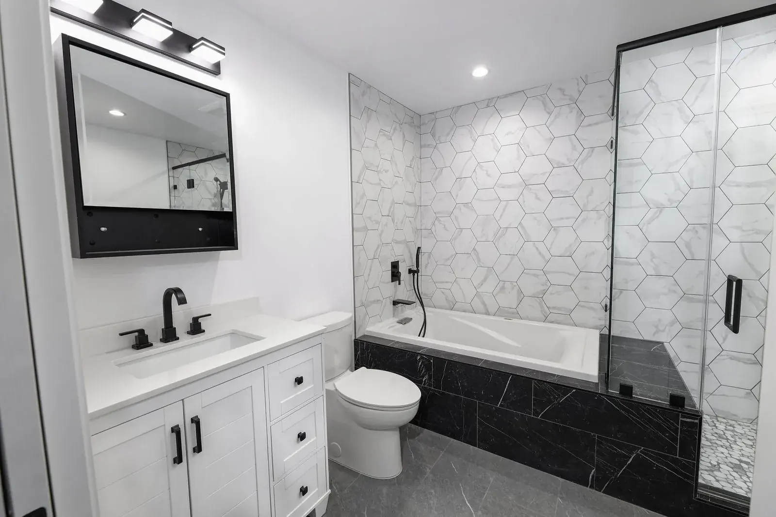 Bathroom with tiled shower and vanity